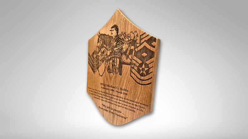 Pu&ograve; includere: Targa in legno dalla forma unica, con un'illustrazione incisa di una persona a cavallo e insegne militari. La targa include testo inciso con un nome e delle date. Il legno ha una venatura naturale.