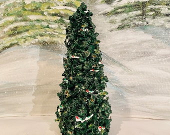 May include: A green, ceramic Christmas tree with white and red ornaments. The tree is decorated with white snow and has a black base.