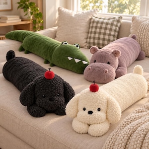 May include: Four plush stuffed animals in a long cylindrical shape. There is a green crocodile, a mauve hippopotamus, a black dog with a red cherry on its head, and a cream-colored dog with a red cherry on its head. All have soft textures.