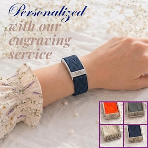 May include: A dark blue woven fabric bracelet featuring a silver-toned metal clasp engraved with the letters MK. The image includes text stating Personalized with our engraving service and smaller inset images showing orange, gray, white, and blue bands.