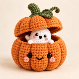 May include: A crocheted orange pumpkin with a smiling face and pink cheeks, featuring a removable lid with a green stem and leaves. Inside the pumpkin sits a small, white crocheted ghost with black eyes, a black mouth, and pink cheeks.