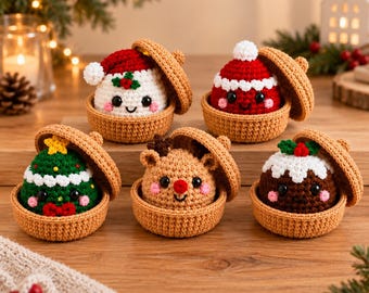 May include: Five small, round, crocheted figures nestled in tan, bowl-shaped containers with matching lids. The figures include a white snowman with a red hat, a red-hatted character, a green Christmas tree, a tan reindeer, and a brown pudding.