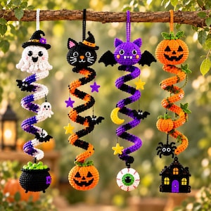 May include: Four hanging crochet decorations featuring Halloween themes. The first has a ghost and cauldron, the second a black cat and pumpkin, the third a purple bat and eyeball, and the fourth a pumpkin and haunted house, all with spiral bodies.