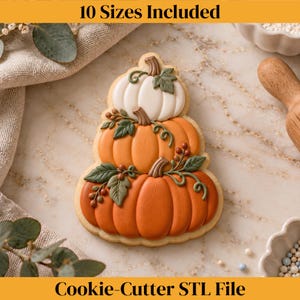 May include: A cookie shaped like a stack of three pumpkins with white and orange icing, green leaves, and brown stems. The text 10 Sizes Included and Cookie-Cutter STL File is displayed at the top and bottom of the image in black lettering.
