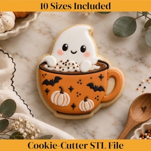 May include: A cookie shaped like an orange mug filled with a white ghost and whipped cream. The mug features black bat and white pumpkin designs. Text at the top reads 10 Sizes Included and at the bottom reads Cookie-Cutter STL File.