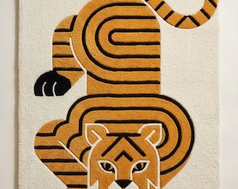 May include: A rectangular tufted rug featuring a stylized tiger design in shades of mustard yellow, black, and white. The tiger is depicted in a crouching position with a curved tail, bold black stripes, and a white face, set against a cream background.