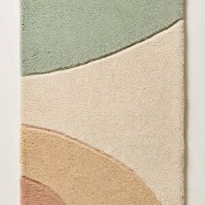 May include: A rectangular runner rug featuring a tufted texture with abstract, curved color-blocked sections in shades of light blue, sage green, cream, tan, terracotta, and deep rust, separated by carved grooves in the pile.
