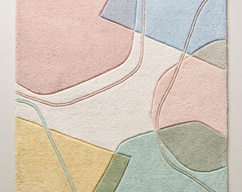 May include: A rectangular area rug featuring a tufted texture with an abstract pattern of organic shapes in pastel pink, light blue, sage green, and soft yellow, separated by recessed lines on a cream-colored background with a small logo.