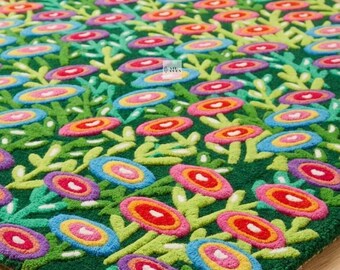 May include: A rectangular tufted rug with a deep green background featuring a repeating pattern of stylized flowers in vibrant shades of pink, orange, yellow, blue, and purple. The design includes small green stems and leaves between the blooms.