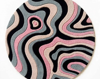 May include: A circular rug featuring a tufted, high-low pile texture with an abstract pattern of wavy, organic lines. The design consists of alternating bands in solid black, soft pastel pink, muted light blue, and creamy beige colors.