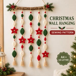 May include: A Christmas wall hanging sewing pattern featuring five vertical strands suspended from a textured wooden branch. The strands include fabric leaves, red poinsettia flowers, wooden beads, and cream tassels. Text reads: CHRISTMAS WALL HANGING SEWING PATTERN and A4 + US LETTER.