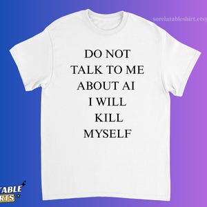 May include: A white short-sleeved t-shirt featuring black text centred on the chest that reads: DO NOT TALK TO ME ABOUT AI I WILL KILL MYSELF. The shirt has a crew neckline and a standard fit, presented against a blue and purple gradient background.