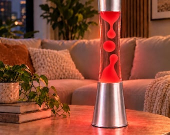 May include: A tall, cylindrical lava lamp featuring a silver metallic base and cap. The clear glass vessel contains a vibrant red liquid with suspended, amorphous red wax shapes that are illuminated from within by a warm light.