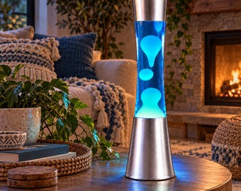 May include: A tall, cylindrical lava lamp featuring a silver metal base and cap. The glass vessel contains a clear liquid with floating, amorphous blobs of bright blue wax that are illuminated from the bottom by a light source.