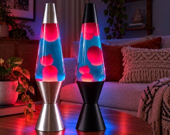 May include: Two lava lamps with conical bases and caps. The left lamp has a silver finish, and the right lamp has a black finish. Both glass vessels contain blue liquid with floating, illuminated pink wax blobs that create a glowing effect.