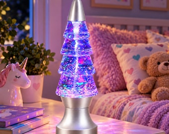 May include: A Christmas tree-shaped glitter lamp with a silver base and top cap. The clear, tiered body is filled with liquid and multicolored glitter that glows with internal LED lights, creating a swirling, illuminated effect.