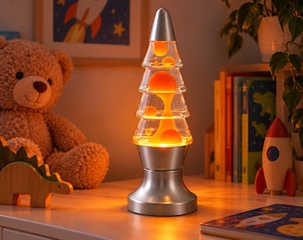 May include: A Christmas tree-shaped lava lamp with a silver base and top, containing clear liquid and orange wax blobs. The lamp emits a warm orange glow, illuminating the surrounding space with a soft light while the wax moves inside.