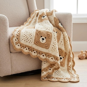 Può includere: Una coperta all'uncinetto con motivi quadrati alternati tra disegni traforati color crema e quadrati marrone chiaro con volti di orso ricamati. La coperta presenta un bordo smerlato in filato beige e crema dall'aspetto strutturato.