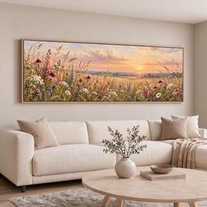 May include: A panoramic landscape painting in a light wood frame depicting a field of wildflowers, including pink coneflowers and white daisies, under a soft sunset sky with golden light illuminating the tall grasses and distant horizon.