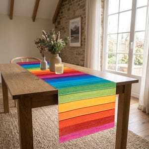 May include: A rectangular table runner featuring a vibrant horizontal striped pattern in rainbow colors including red, orange, yellow, green, blue, and purple. The design mimics the appearance of painted wooden planks with a visible grain texture.