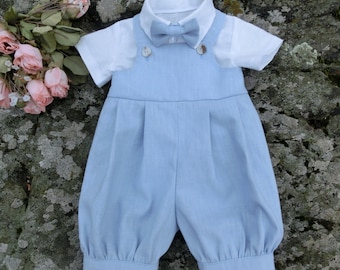 May include: A light blue baby outfit with a white shirt and a bow tie. The outfit has a bib-like top with buttons and a pair of pants with a gathered waist.