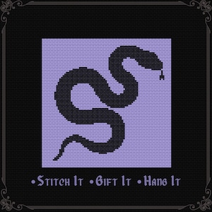 May include: A cross-stitch pattern featuring a black snake silhouette centered on a light purple square background. Below the square, the text reads "Stitch It • Gift It • Hang It" in a purple gothic-style font against a black background.