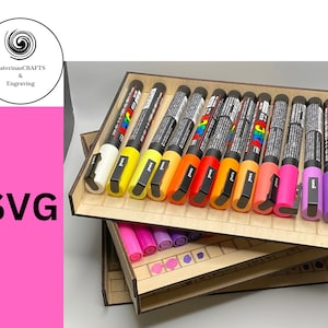 Puede incluir: Un organizador de madera con tres niveles para guardar marcadores. El nivel superior tiene 14 marcadores en un arcoíris de colores, incluyendo blanco, amarillo, naranja, rojo, rosa y morado. Los dos niveles inferiores tienen compartimentos más pequeños para guardar marcadores adicionales.