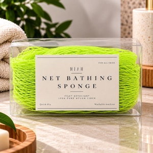 Puede incluir: Una esponja de baño de red color verde neón hecha de 100% fibra de nailon pura, empaquetada en una caja rectangular transparente. La etiqueta dice NIAH NET BATHING SPONGE, FOR ALL SKINS, FILET EXFOLIANT, 100% PURE NYLON FIBER, Quick dry, Washable machine.
