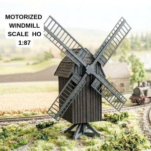 Può includere: Un modello di mulino a vento motorizzato marrone scuro in scala HO 1:87. La struttura presenta un esterno con texture effetto legno, un tetto a scandole e quattro grandi pale a traliccio. Il testo sull'immagine recita: MOTORIZED WINDMILL SCALE HO 1:87.
