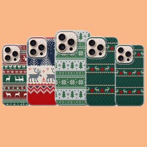 Puede incluir: Cinco fundas para smartphone con patrones festivos. Los diseños incluyen motivos repetidos de renos, pinos y copos de nieve en colores rojo, verde, blanco y azul marino. Cada funda tiene un recorte para un sistema de cámara de tres lentes.