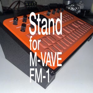 May include: A black angled stand holding an orange M-VAVE FM-1 synthesizer. The stand features a textured finish and supports the device at an incline. The text Stand for M-VAVE FM-1 is overlaid on the image, highlighting the product's compatibility.