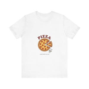 Könnte beinhalten: Ein weißes Kurzarm-T-Shirt mit einer Grafik einer Peperoni-Pizza, bei der ein Stück abgetrennt ist. Über der Pizza steht das Wort PIZZA in roten Buchstaben, darunter befinden sich eine gekreuzte Gabel und ein Messer mit dem Text ANOTHER SLICE.