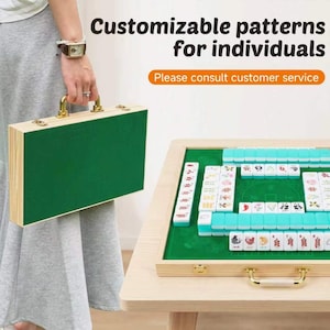 May include: A wooden mahjong set in a green carrying case with gold-tone latches and handles. The set includes tiles with various colourful floral and animal designs. Text on the image reads: Customizable patterns for individuals. Please consult customer service.