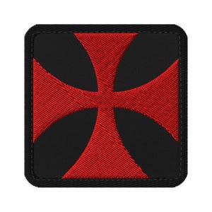 May include: A square embroidered patch featuring a bold red cross pattée design centered on a solid black background. The patch has a thick, stitched black border that frames the square shape, with visible thread texture throughout the design.
