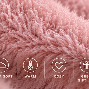 Puede incluir: Un primer plano de una tela de piel sint&eacute;tica de color rosa empolvado con pelo largo y textura peluda. En la parte inferior hay cuatro iconos circulares blancos con una nube, un term&oacute;metro, un coraz&oacute;n y un regalo, con el texto ULTRA SOFT, WARM, COZY, GREAT GIFT IDEA.