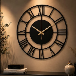 Könnte beinhalten: Eine große, runde Wanduhr mit einem schwarzen Metallrahmen und ausgeschnittenen römischen Ziffern. Die Mitte besteht aus einem massiven schwarzen Zifferblatt mit dünnen, goldfarbenen Zeigern für Stunden, Minuten und Sekunden.