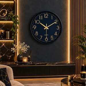 May include: A round wall clock with a dark blue face, gold-coloured numerals, and gold-coloured hands. The clock features a thin dark blue frame and the word QUARTZ printed in gold below the centre point where the hands are attached.