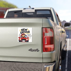 Op de afbeelding: Een vierkante witte bumpersticker met de tekst NEW DRIVER in dikke zwarte letters. Daaronder staat een cartoonillustratie van een persoon met een rode pet in een rode auto, met de tekst Please be patient... I'm trying! en een smiley.