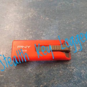 May include: A red PNY 12GB USB flash drive with a black slider. The text "Stealth Key Logger" is written in blue on the image.