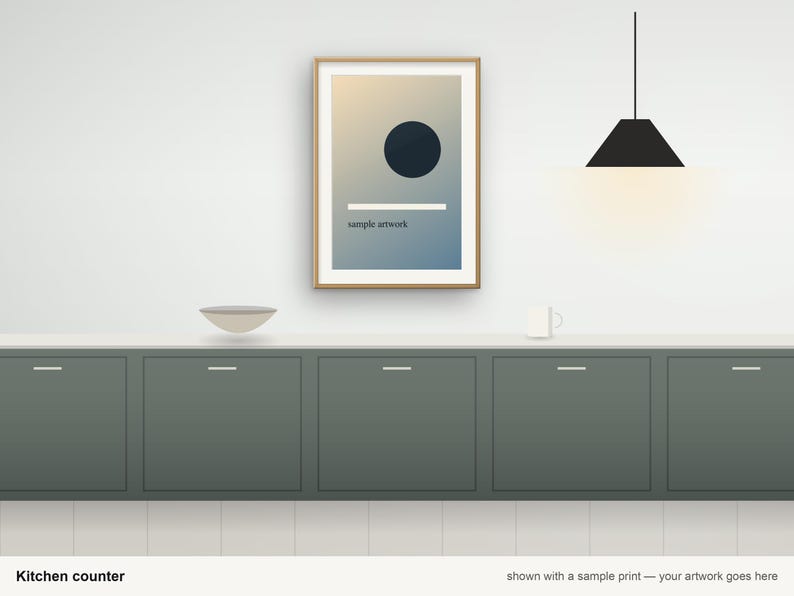 May include: A framed rectangular print featuring a dark circle and a horizontal white line over a gradient background, hanging above a dark green kitchen counter with a bowl, a mug, and a black pendant light fixture.
