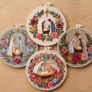 Peut inclure: Quatre tambours à broder circulaires présentant des scènes de nativité détaillées. Chaque tambour montre Marie, Joseph et l'enfant Jésus entourés de couronnes florales colorées et d'une étoile dorée. Les tissus varient en crème, gris et beige.