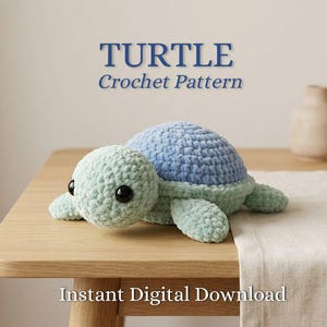 Könnte beinhalten: Eine gehäkelte Plüschschildkröte mit hellgrünem Kopf und Gliedmaßen sowie einem blauen Panzer, ausgestattet mit großen schwarzen Kunststoffaugen. Der Text TURTLE Crochet Pattern und Instant Digital Download ist sichtbar.