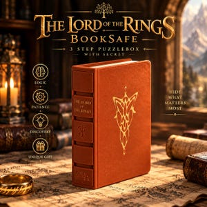 May include: A rust-coloured book safe titled The Lord of the Rings, featuring a 3-step puzzle box mechanism. The cover displays a gold leaf emblem, while the spine includes the title, the One Ring inscription, and a tree icon in gold relief.