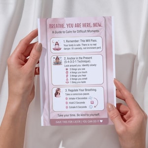 May include: A rectangular informational card titled BREATHE. YOU ARE HERE. NOW. A Guide to Calm for Difficult Moments. It features three numbered steps for anxiety management, including grounding techniques and breathing exercises with icons and text.