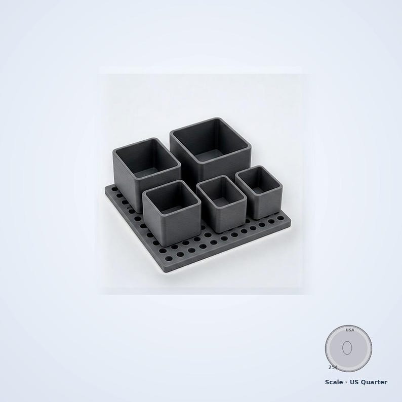 May include: A dark gray modular desk organizer set featuring a square base plate with a grid of circular holes and five removable square containers of varying heights. A US quarter coin is included for scale, measuring 0.955 inches in diameter.