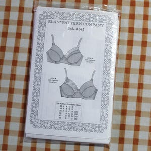 May include: A sewing pattern packet for a bra by Élan Pattern Company, Style #645. The white paper insert features black line drawings of two bra designs, labeled View A and View B, both with optional lace trim, and a size chart from 32 to 42.