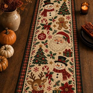 May include: A rectangular quilted table runner featuring a cream-coloured background with a repeating Christmas pattern of snowmen, Santa Claus, reindeer, gingerbread men, decorated pine trees, candy canes, gift boxes, and red poinsettias.