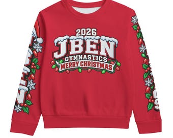 Może przedstawiać: Czerwona bluza z długim rękawem z grafiką zawierającą napis 2026 JBEN GYMNASTICS MERRY CHRISTMAS. Wzór obejmuje ośnieżone litery, liście ostrokrzewu, czerwone jagody i świąteczne lampki. Rękawy ozdobione są pasującym do całości motywem graficznym.