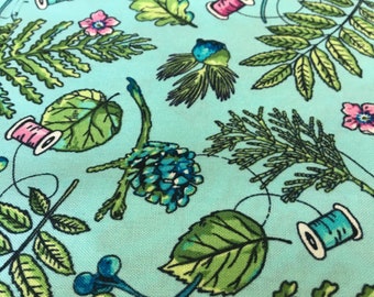 Northcott Cotton Fabric Wild in Turquoise with threads and plants on a turquoise background