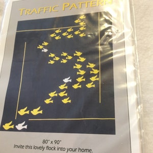 May include: A black and white image of a flock of yellow birds flying in a pattern on a dark blue background. The text "TRAFFIC PATTERN" is at the top of the image. The text "80" x 90" and "Invite this lovely flock into your home." is at the bottom of the image.